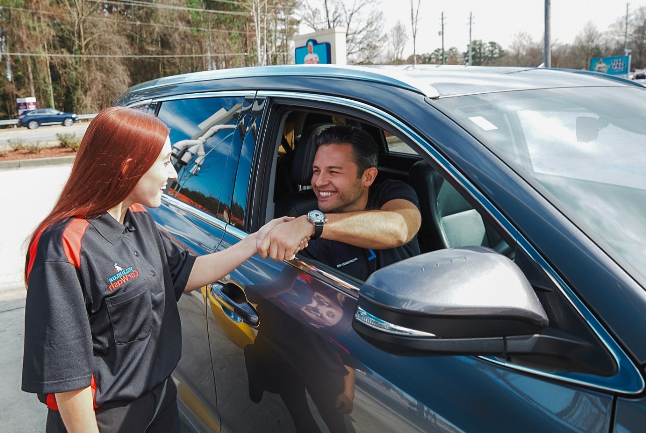 ICA car wash attendant greeting a driver