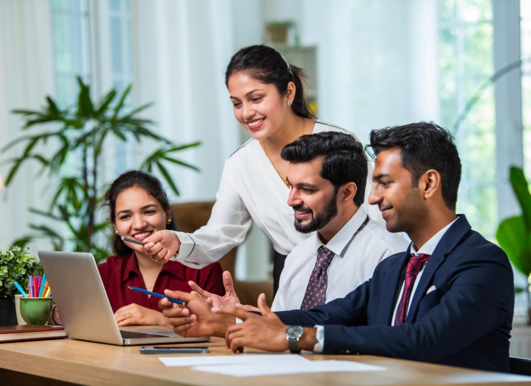 Consultants reviewing work together at a laptop